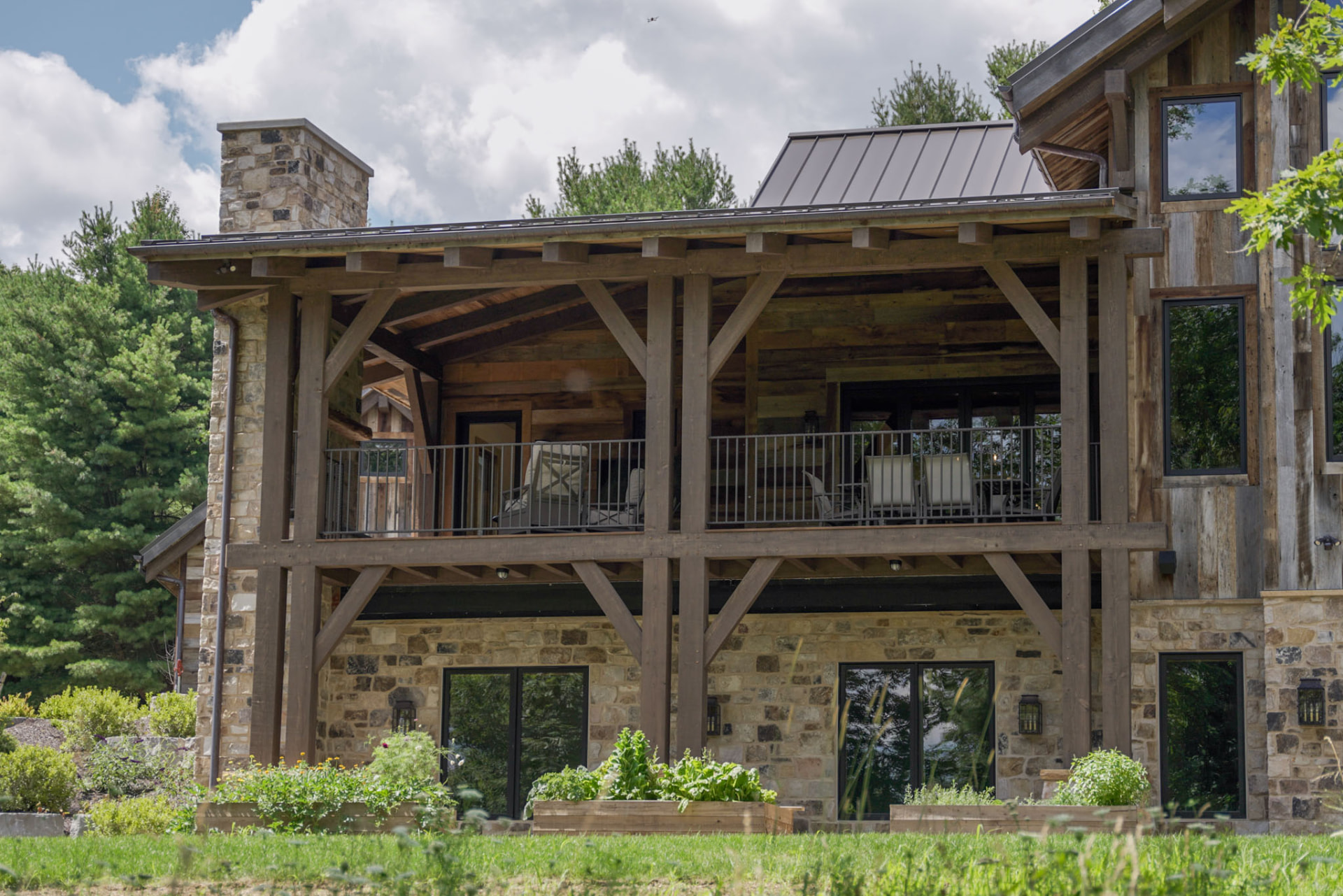 Wright Residence — two-story covered timber deck with stone foundation piers and garden beds below — KB Builders, Central Pennsylvania