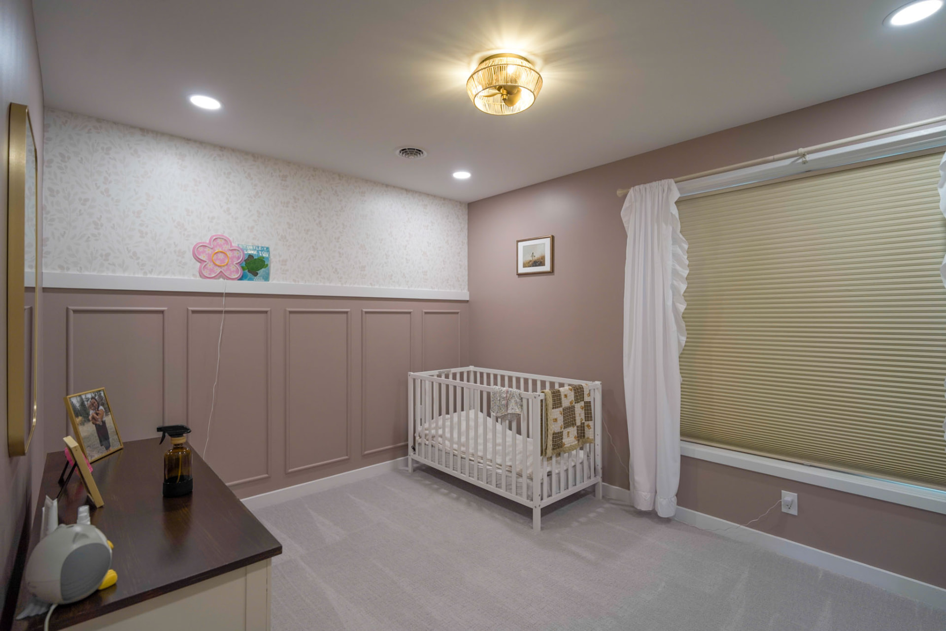 Yoder Residence — nursery with blush paneled wainscoting, floral wallpaper, and brass ceiling light — KB Builders, Central Pennsylvania