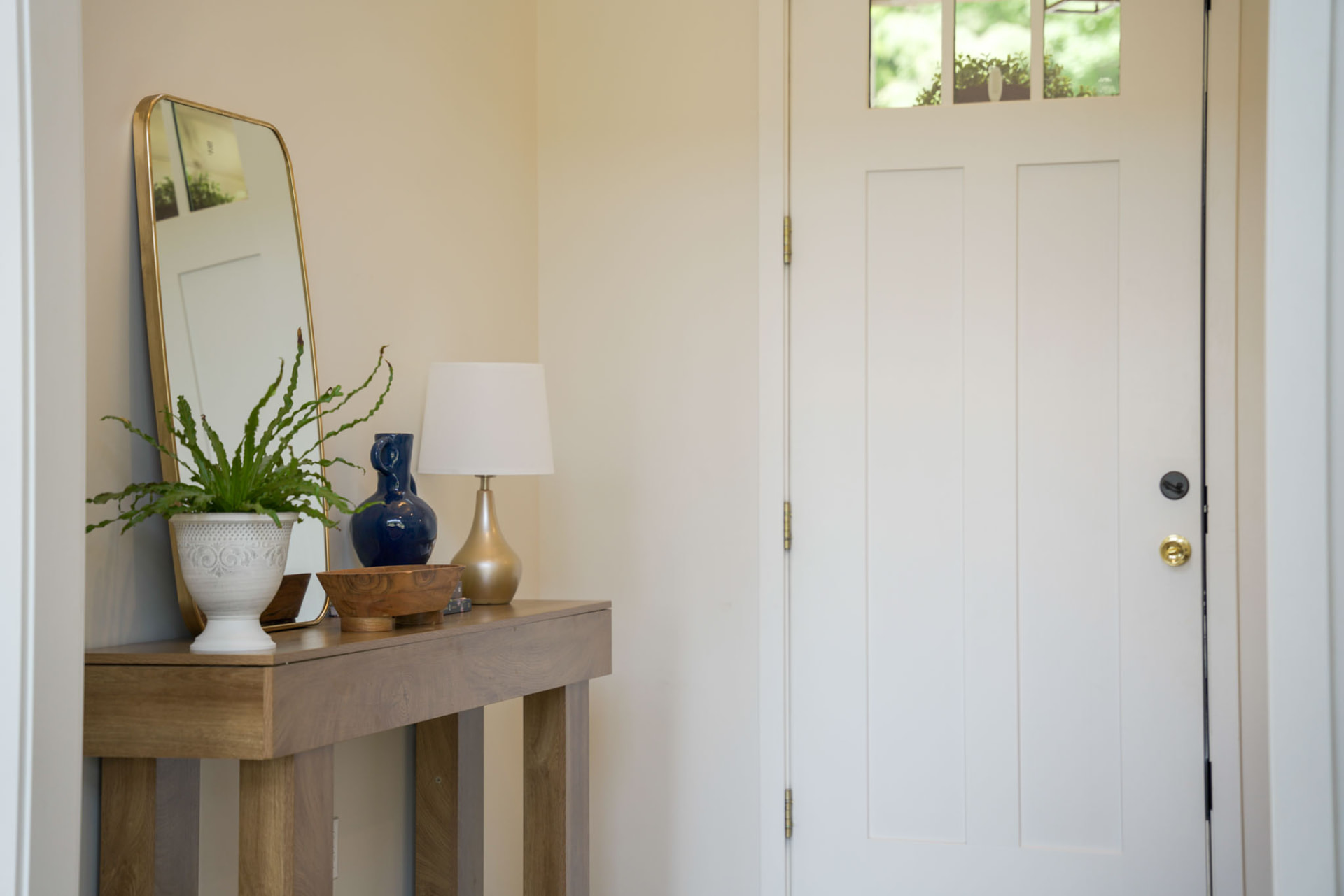 Byler Residence — foyer with oak console table, brass-framed mirror, and craftsman front door — KB Builders, Central Pennsylvania