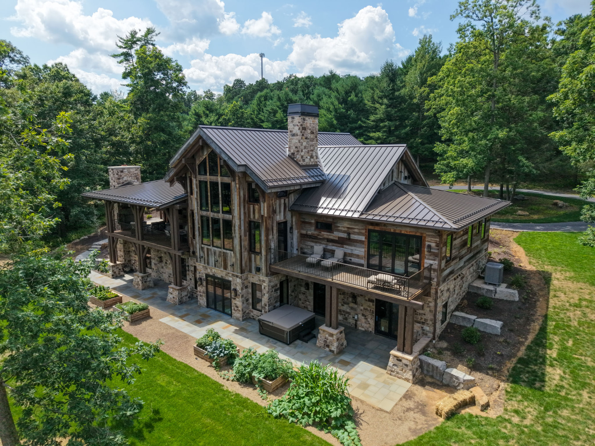 Wright Residence — aerial view of the rear terraces, covered deck, and stone patio with hot tub — KB Builders, Central Pennsylvania
