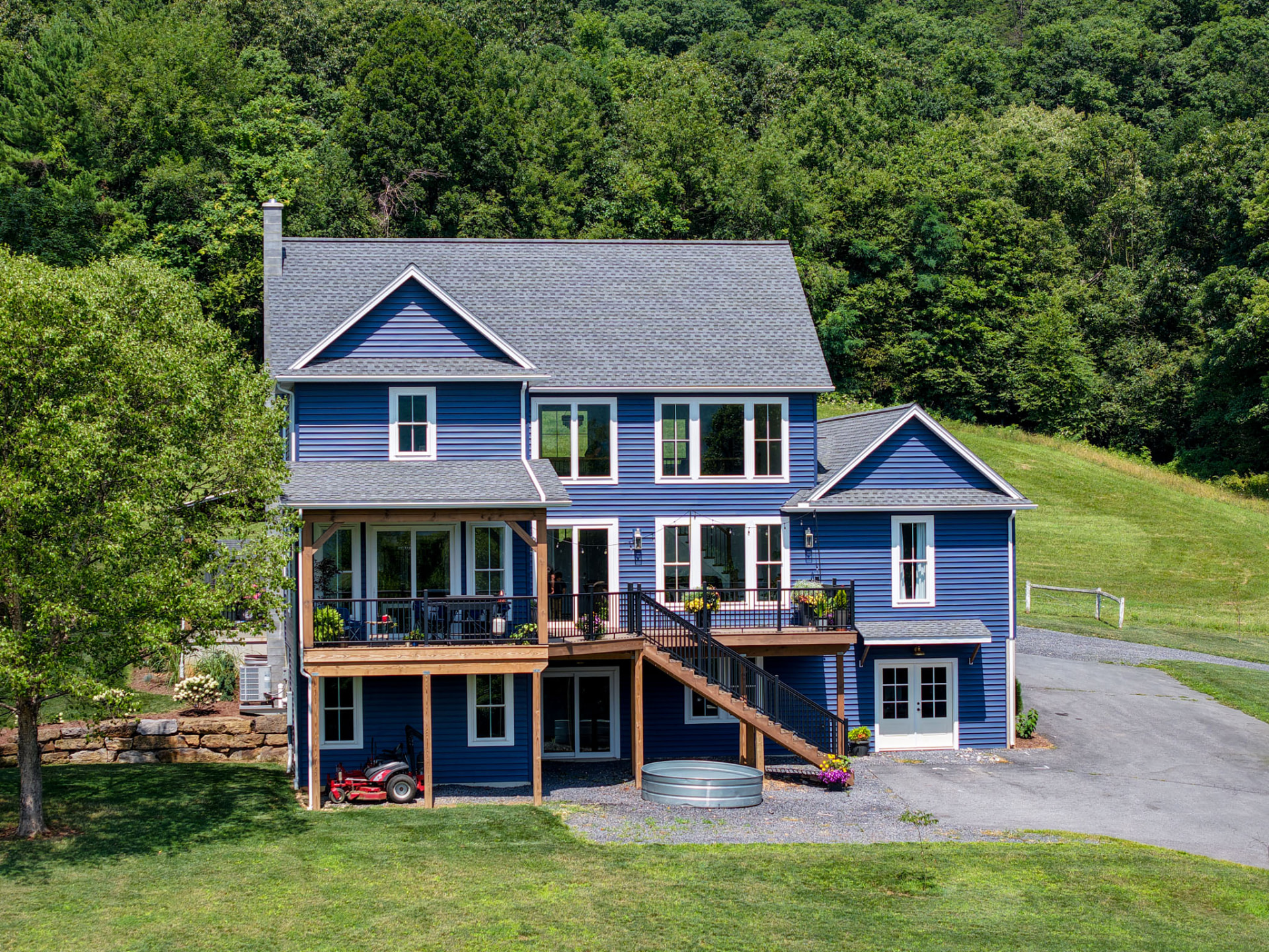 Byler Residence — rear elevation with elevated timber deck, black railings, and walk-out lower level — KB Builders, Central Pennsylvania