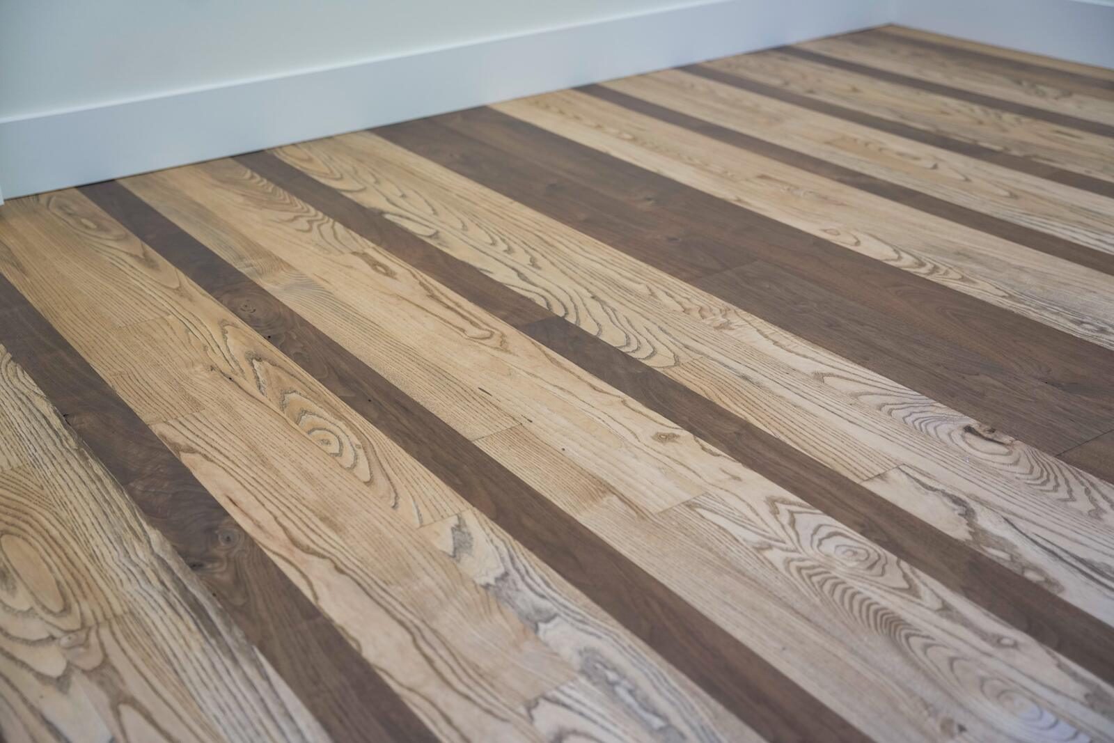 Mixed-species hardwood flooring detail with alternating walnut and ash planks — custom home by KB Builders, Mifflintown, PA