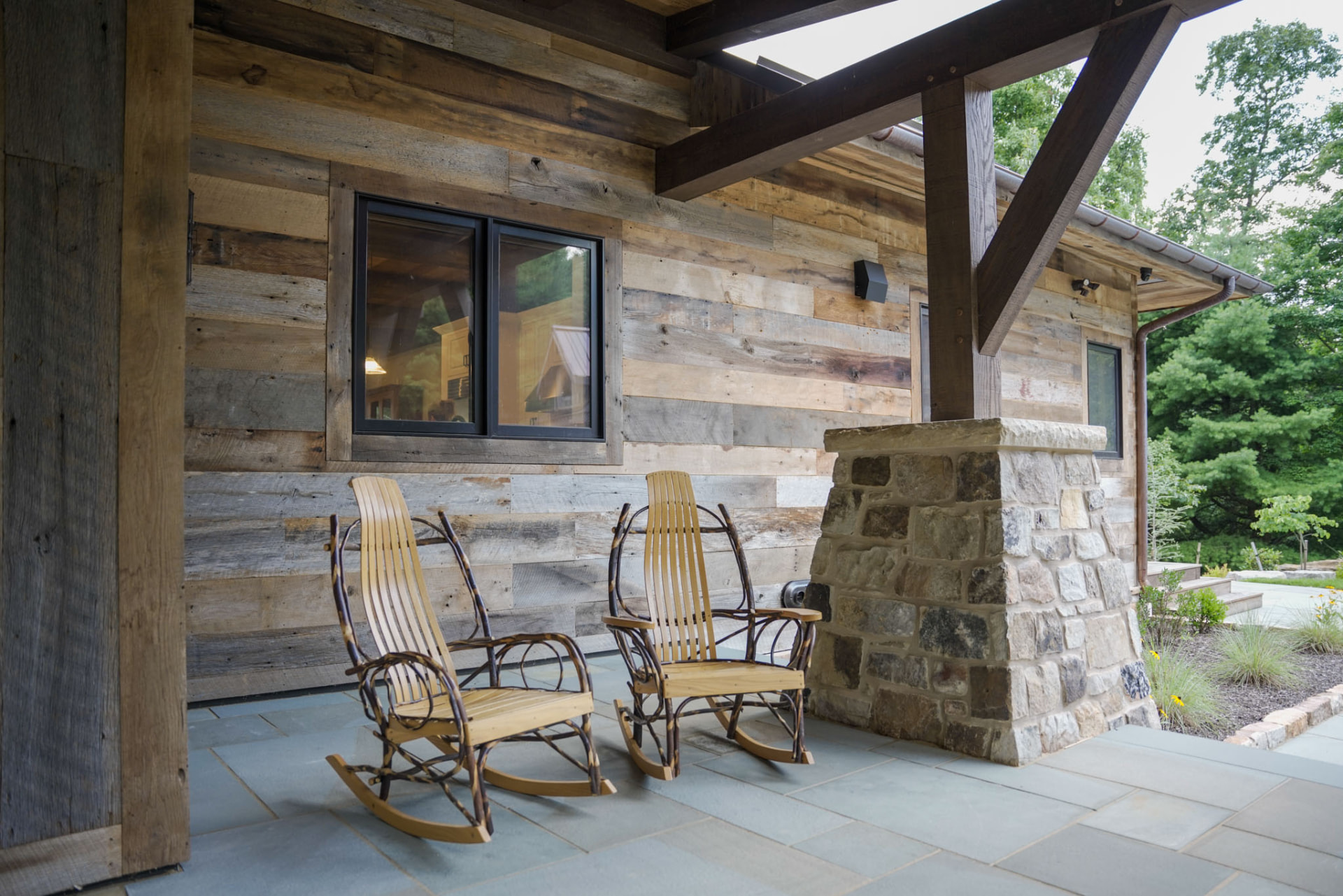 Wright Residence — flagstone porch with handcrafted rocking chairs against reclaimed barnwood siding — KB Builders, Central Pennsylvania