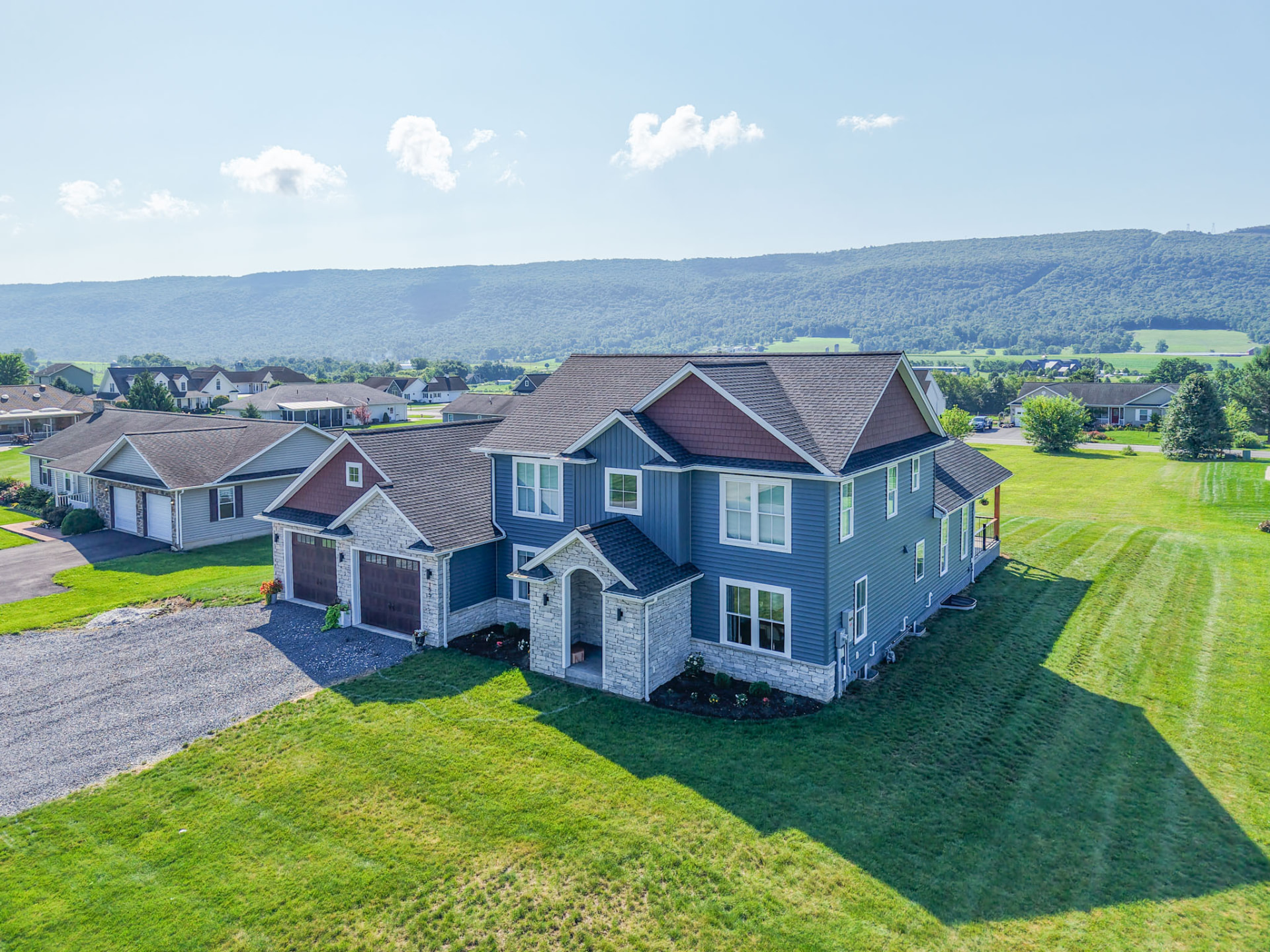 Yoder Residence — aerial view of the custom home and open lawn with mountain ridge beyond — KB Builders, Central Pennsylvania