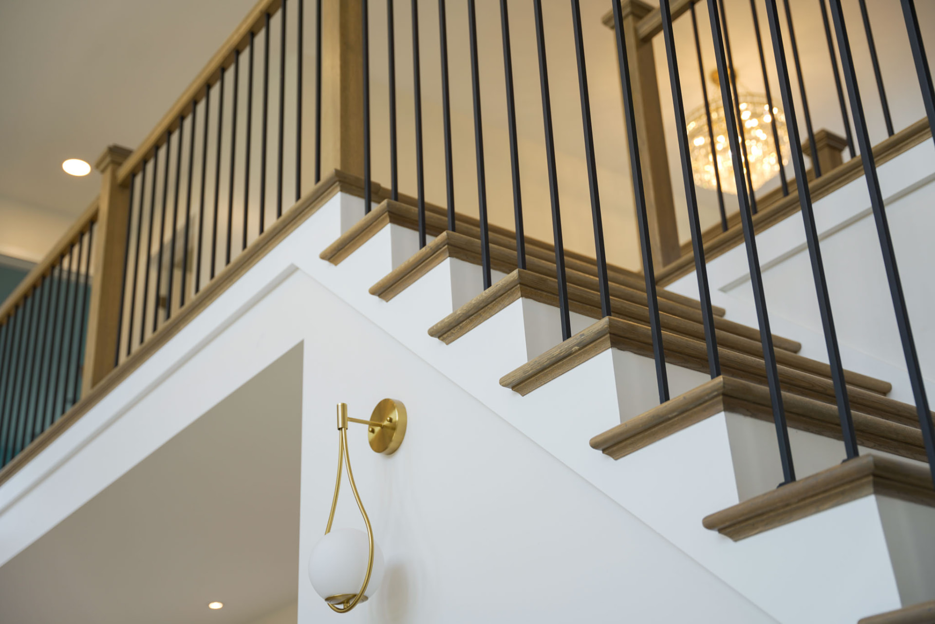 Byler Residence — oak staircase with black metal balusters and brass wall sconce — KB Builders, Central Pennsylvania