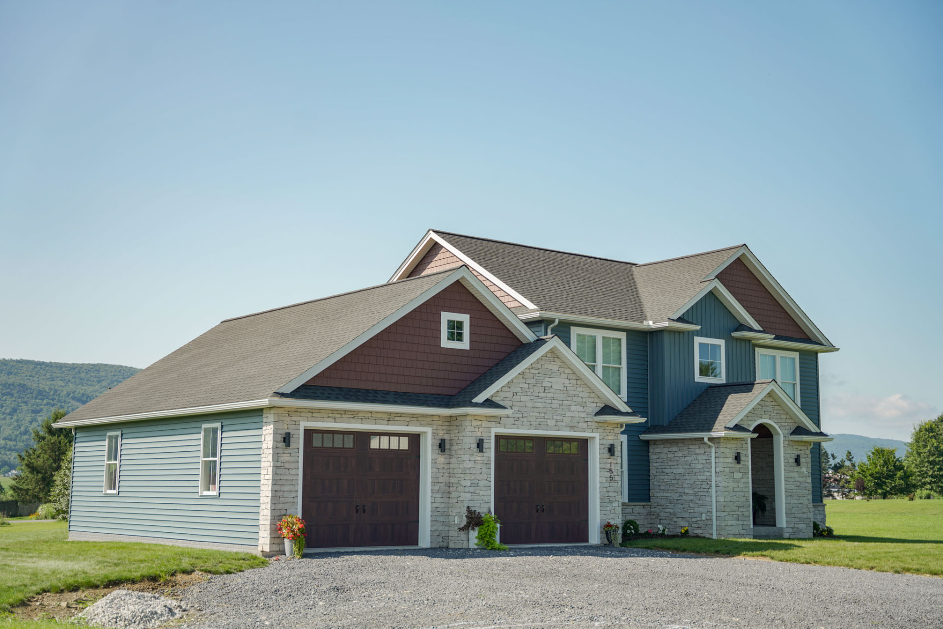 Yoder Residence custom home with blue siding and stone entry by KB Builders, Central Pennsylvania