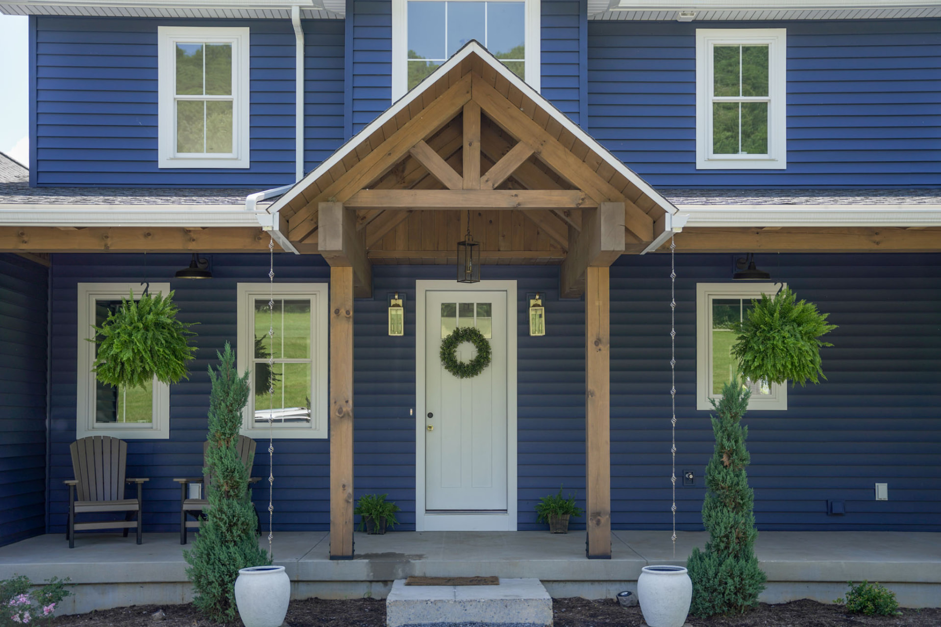 Byler Residence — timber-gabled front entry with craftsman door, rain chains, and hanging ferns — KB Builders, Central Pennsylvania