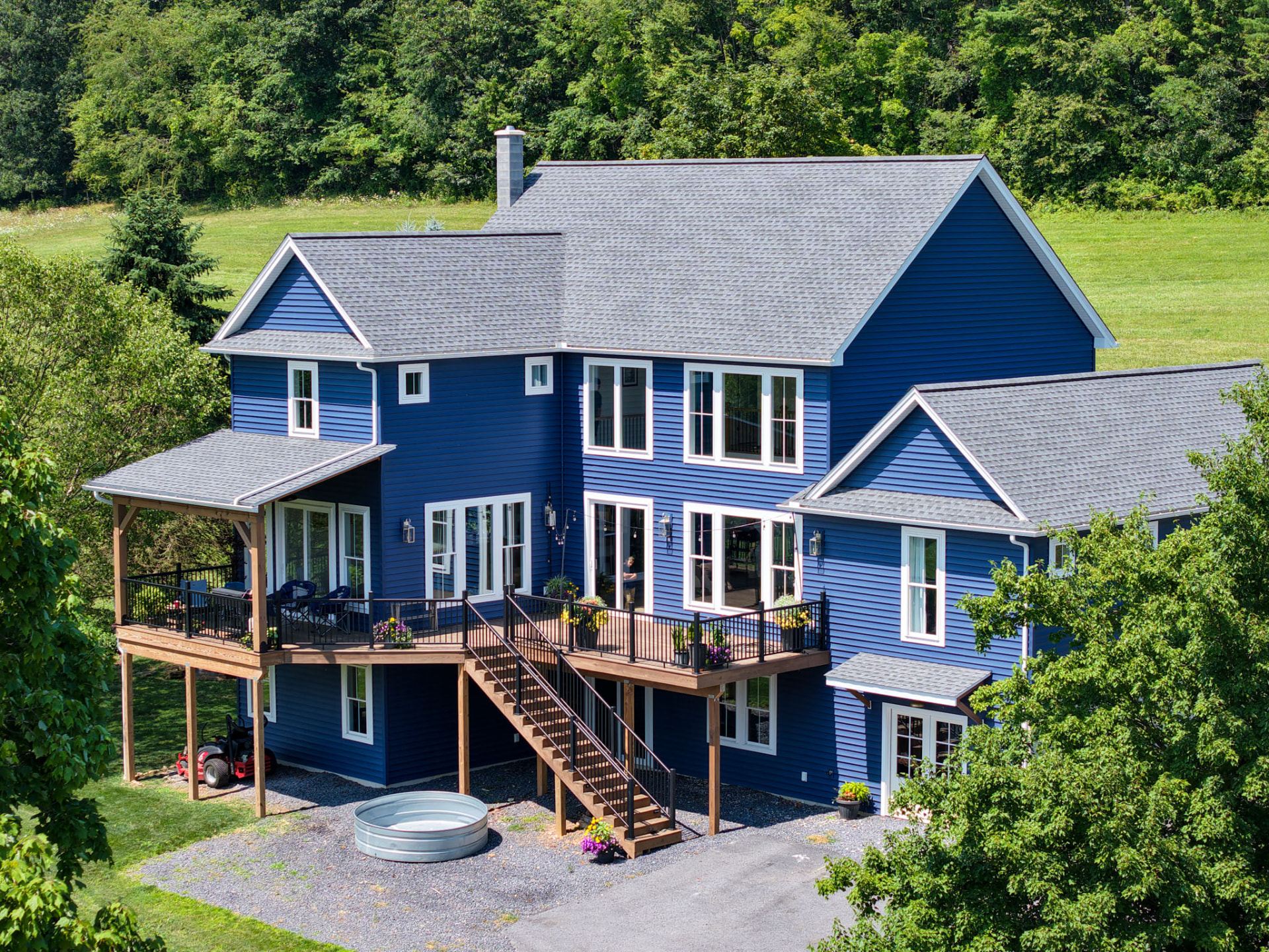 Byler Residence aerial view of a blue custom home with elevated timber deck and walk-out lower level by KB Builders, Central Pennsylvania