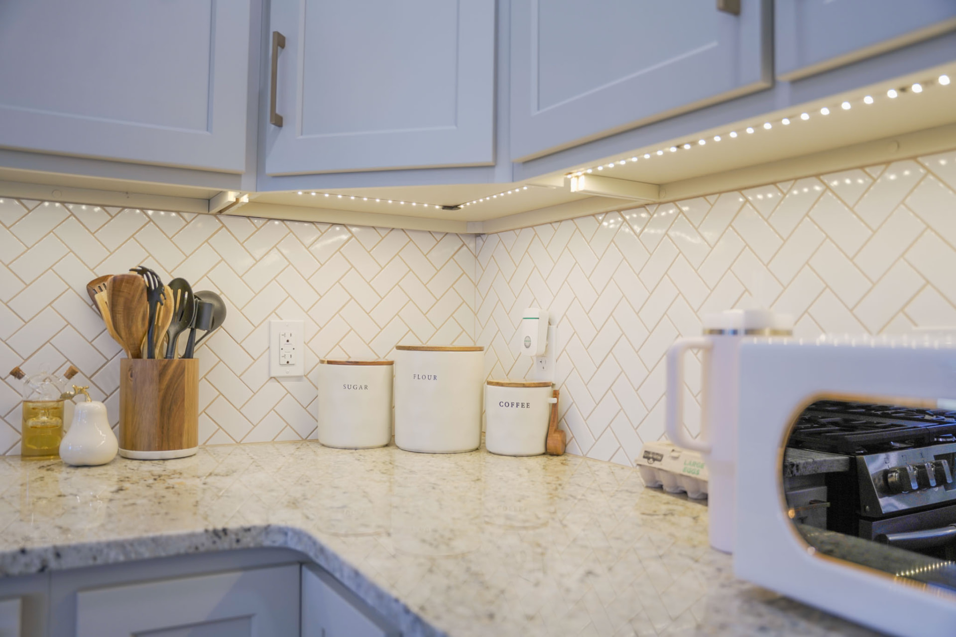Yoder Residence — kitchen corner with herringbone tile backsplash, granite counters, and under-cabinet lighting — KB Builders, Central Pennsylvania