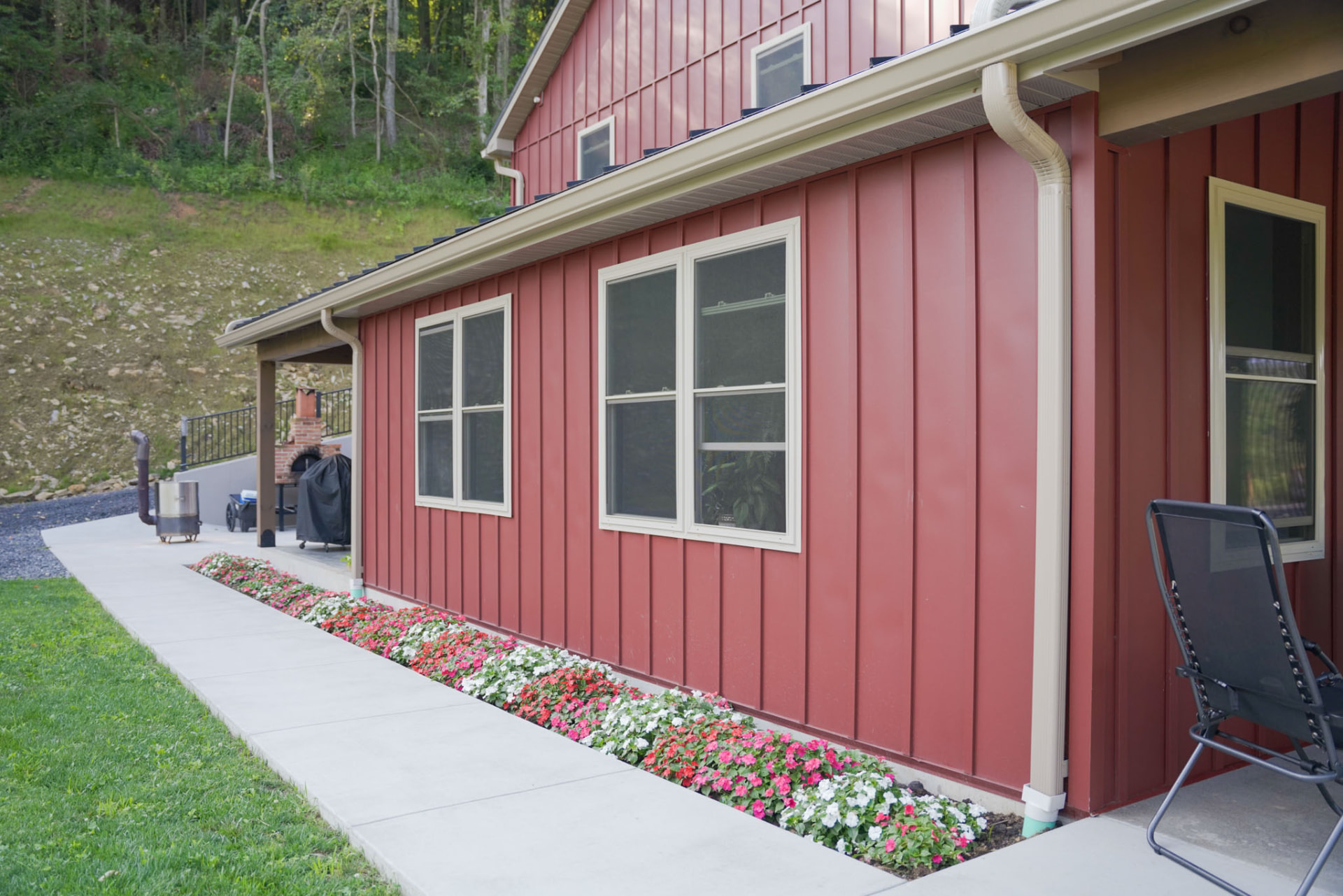 Peachy Residence — board-and-batten siding detail with flower beds and covered walkway on a barndominium by KB Builders, McVeytown, PA
