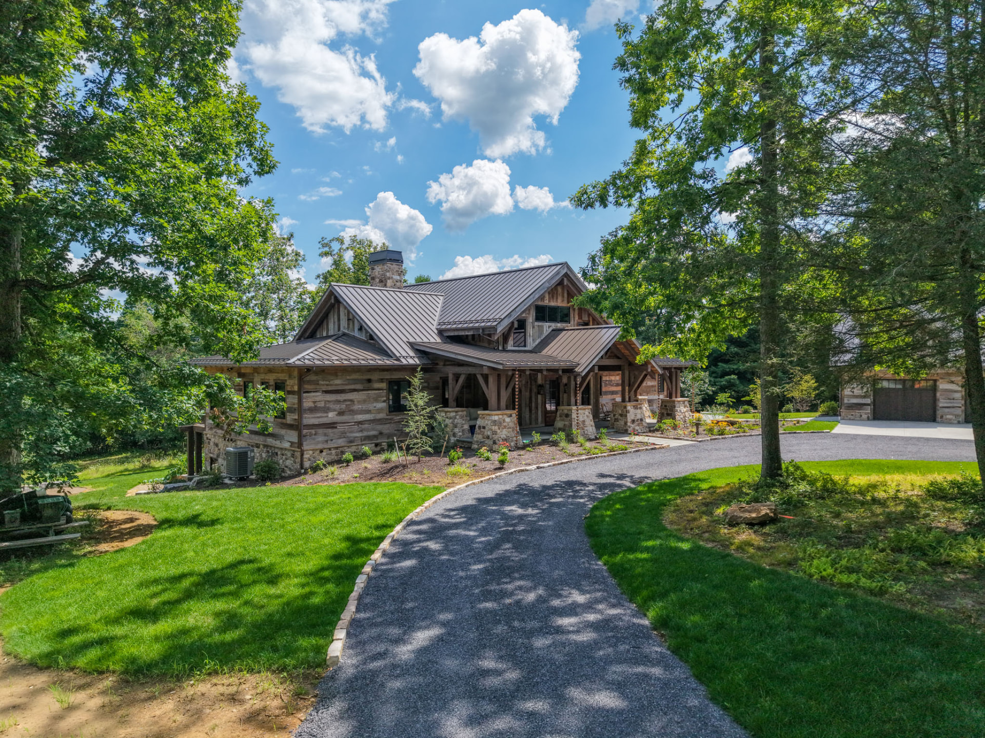 Wright Residence — front approach along a tree-lined gravel drive to the reclaimed wood and stone home — KB Builders, Central Pennsylvania