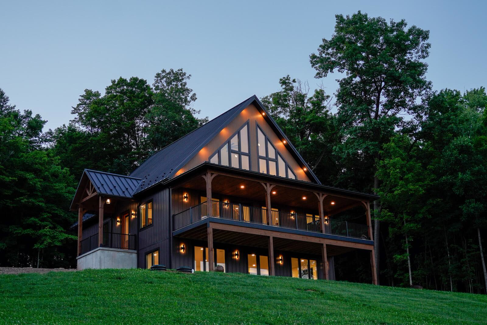 Shetler Residence at twilight with warm interior light through floor-to-ceiling windows — custom home by KB Builders, Mifflintown, PA