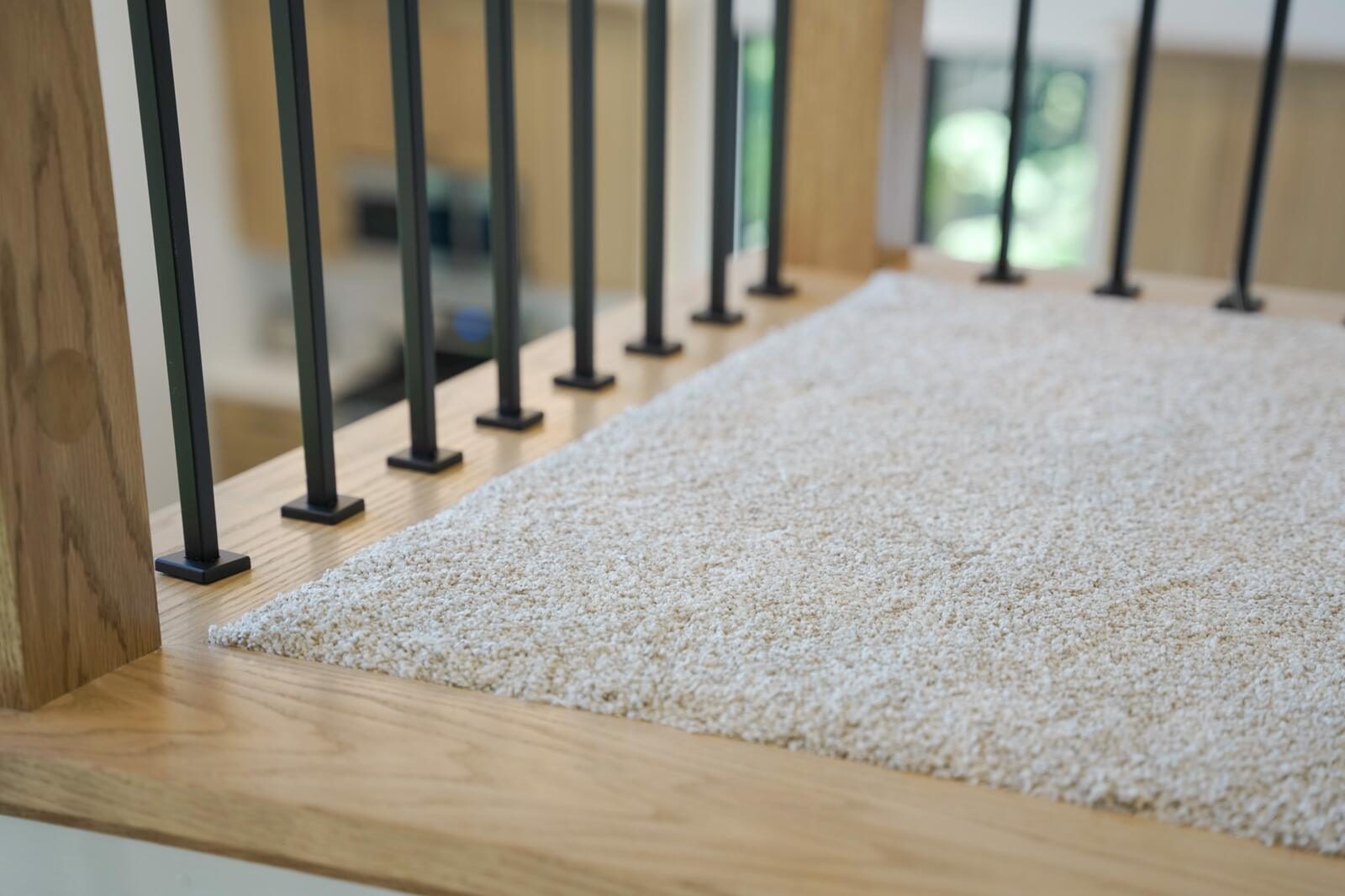 Loft landing detail with wood cap, iron balusters, and plush cream carpet — custom home by KB Builders, Mifflintown, PA