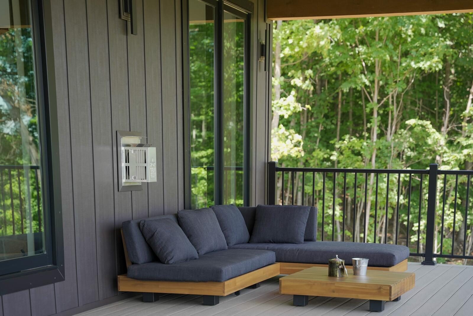 Covered porch with composite decking, black railings, and forest views — Shetler Residence custom build by KB Builders, Mifflintown, PA