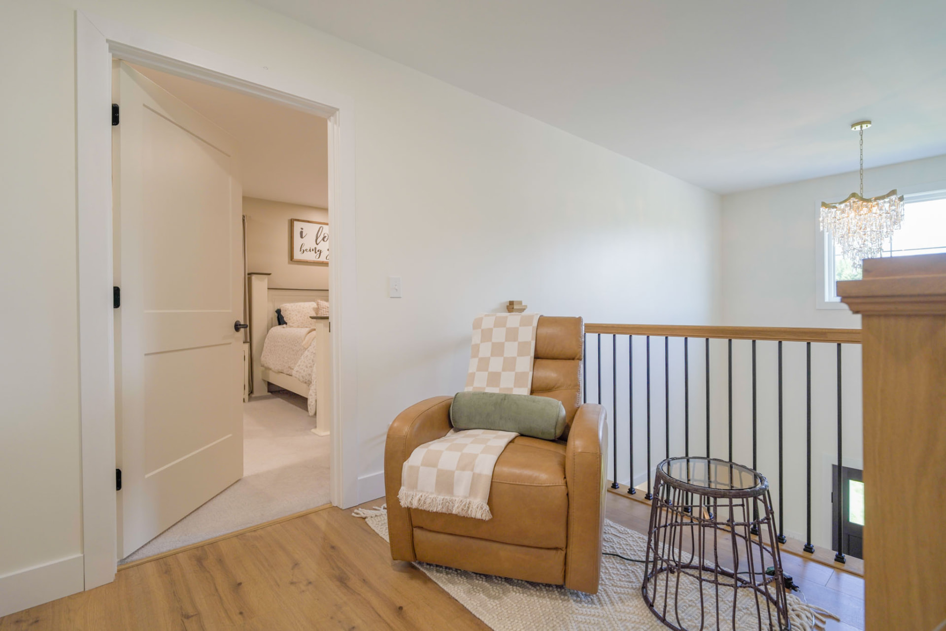 Yoder Residence — upstairs landing with oak railing, iron balusters, and a reading chair — KB Builders, Central Pennsylvania