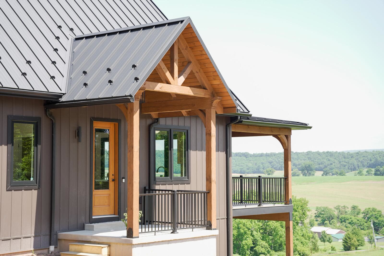 Timber-frame entry portico detail with cedar posts and standing-seam metal roof — custom home by KB Builders, Mifflintown, PA