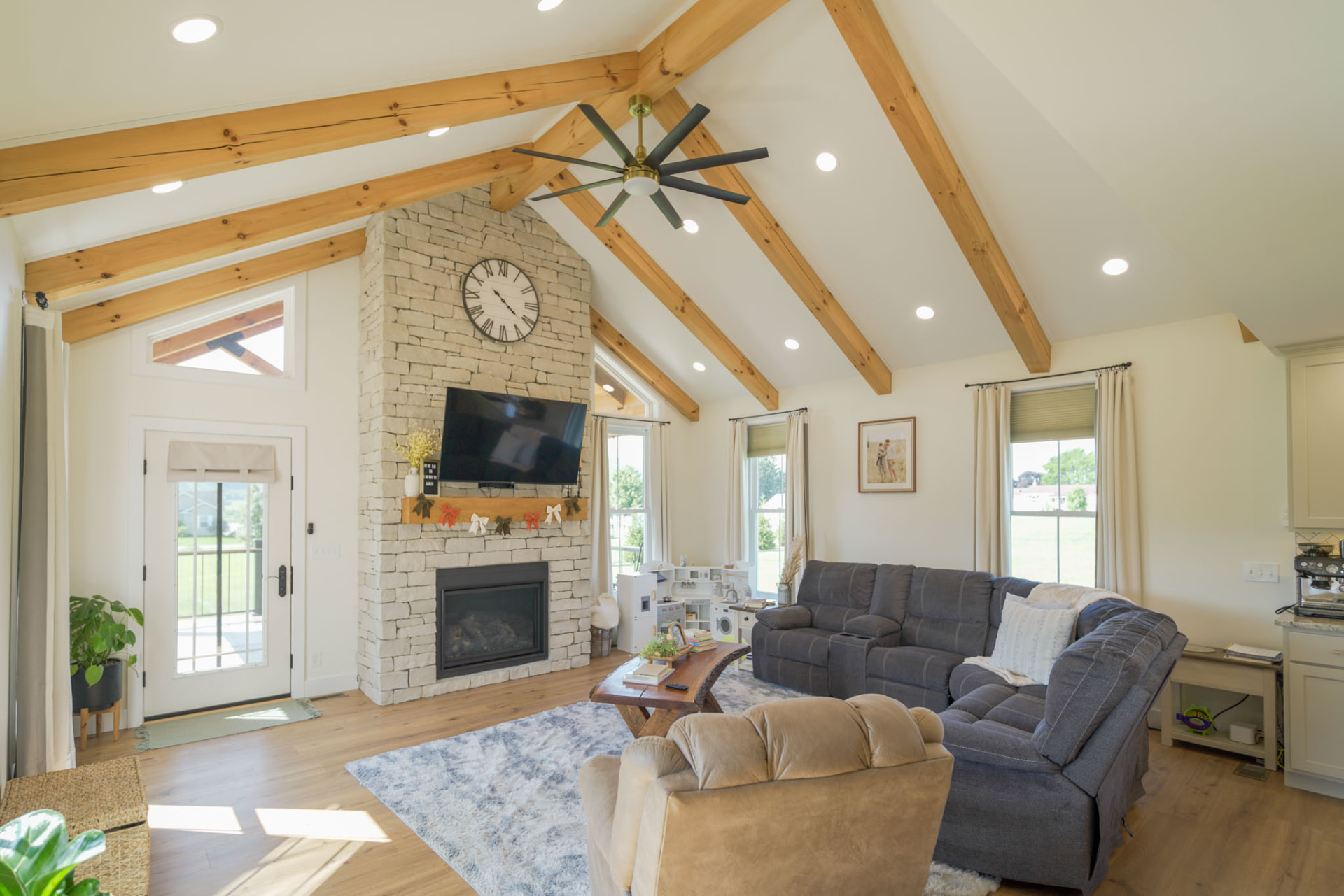 Yoder Residence — vaulted great room with pine beams, stone hearth, and transom windows — KB Builders, Central Pennsylvania