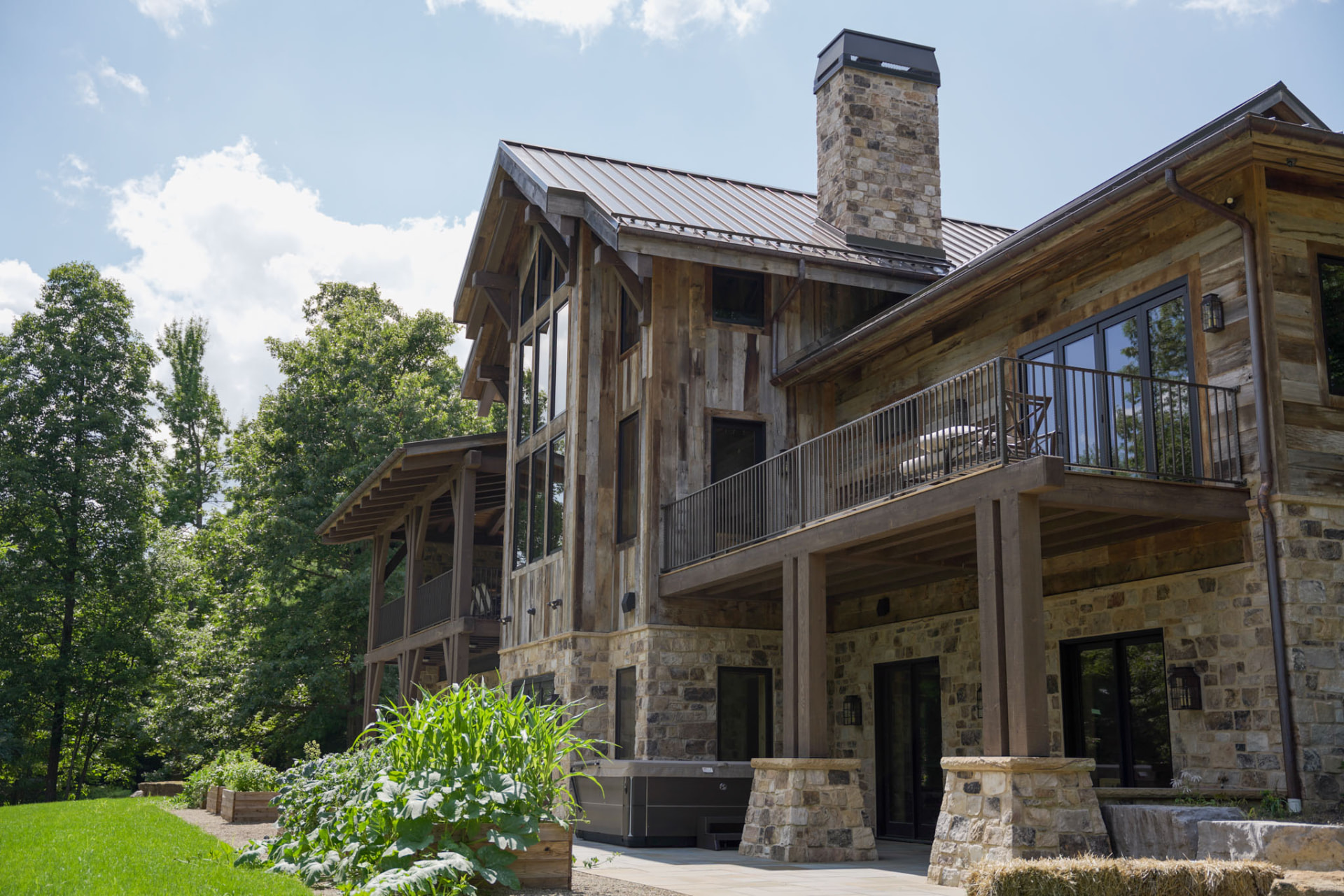 Wright Residence — rear elevation with upper balcony, stone chimney, and walk-out lower level — KB Builders, Central Pennsylvania