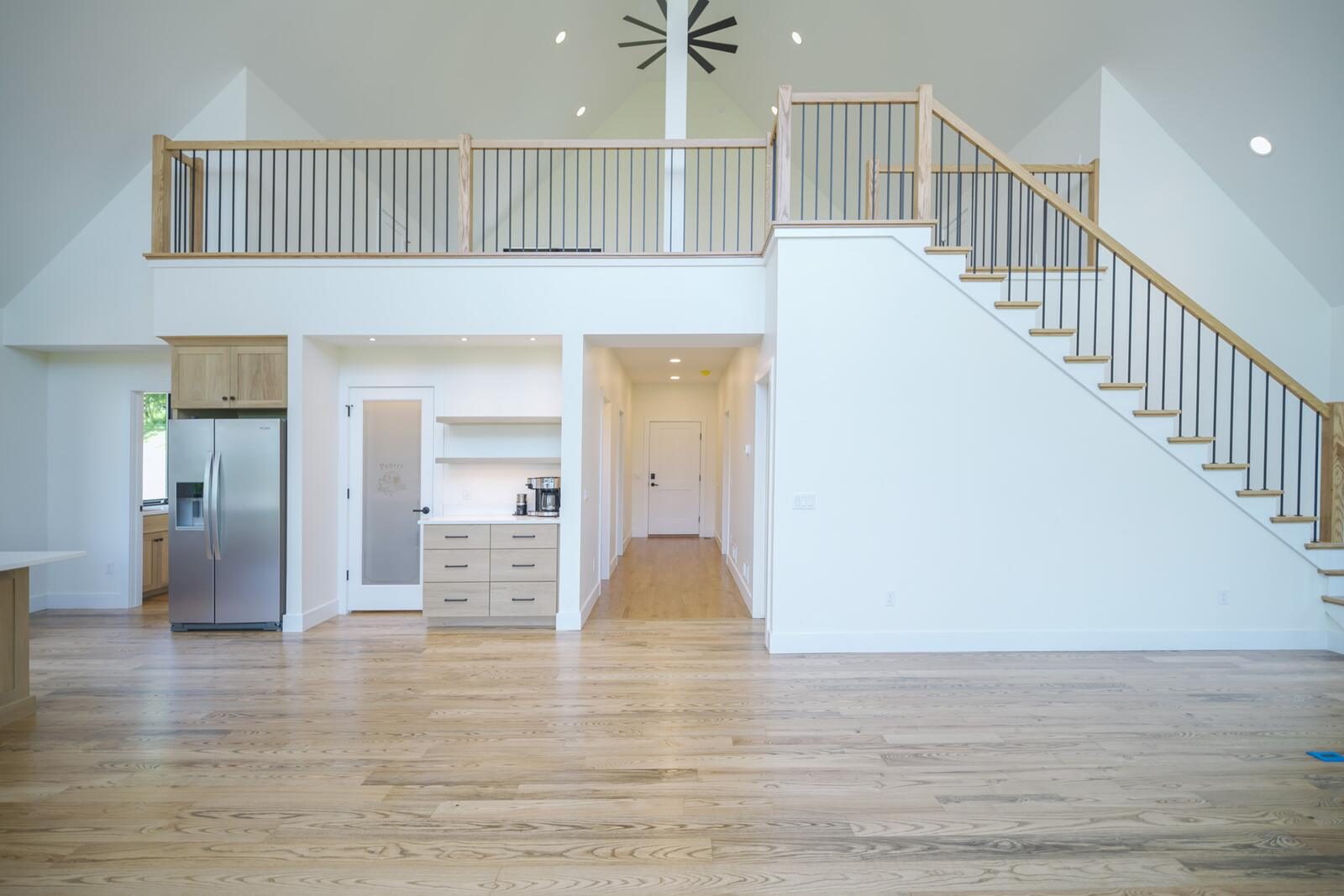 Two-story foyer with open staircase, wood treads, and iron balusters in a custom KB Builders home, Mifflintown, PA
