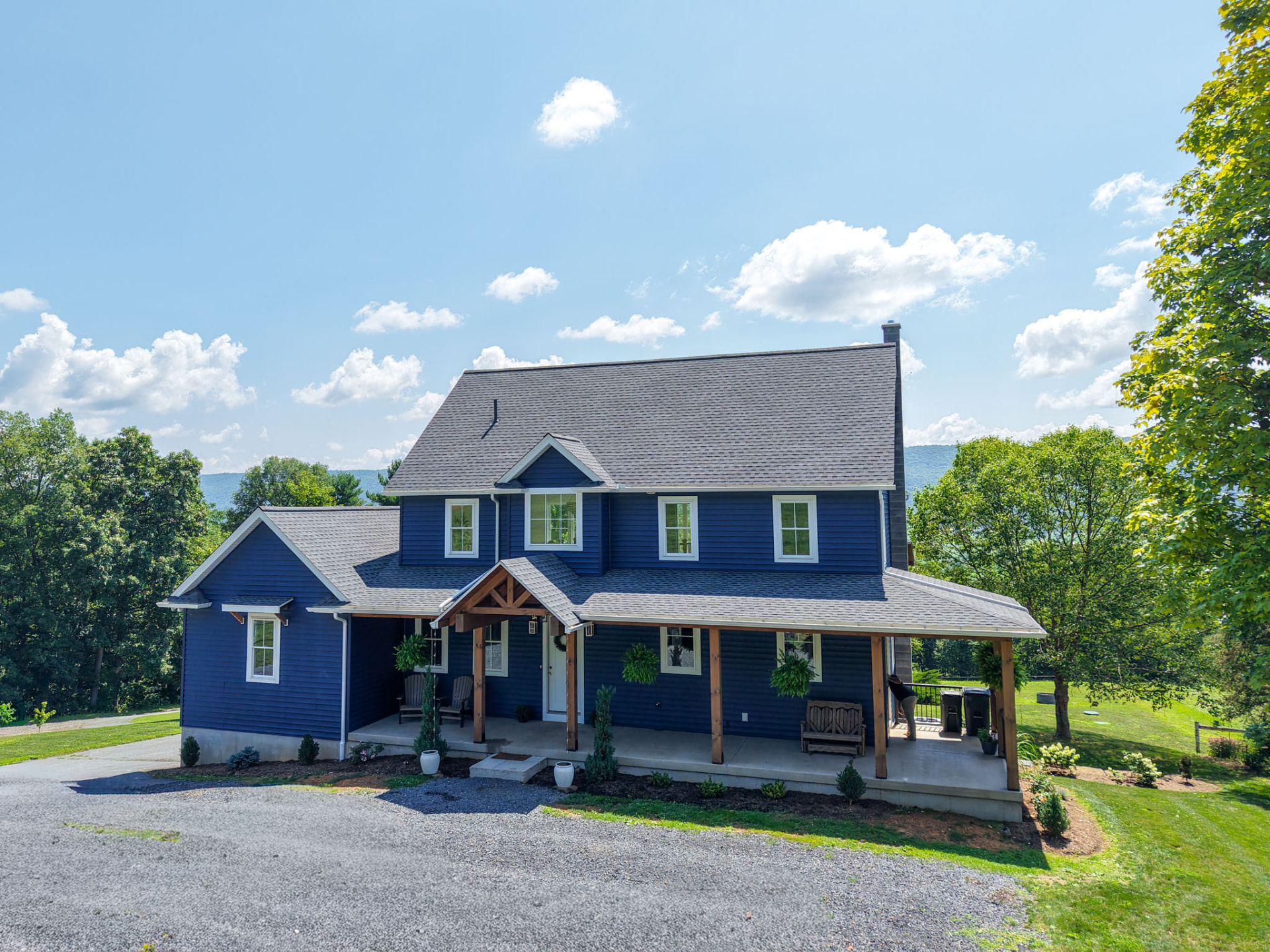 Byler Residence — front elevation of a blue two-story custom home with timber-post covered porch — KB Builders, Central Pennsylvania